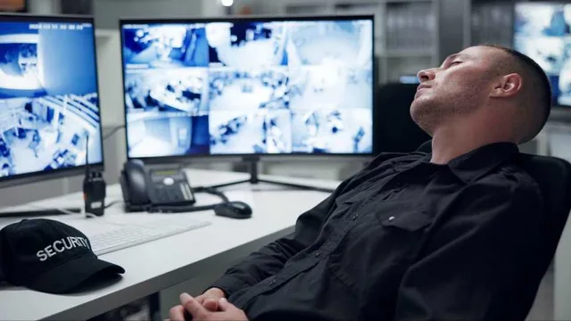 Stock photo from CSO Online: a security guard asleep in a chair in front of a wall of CCTV monitors