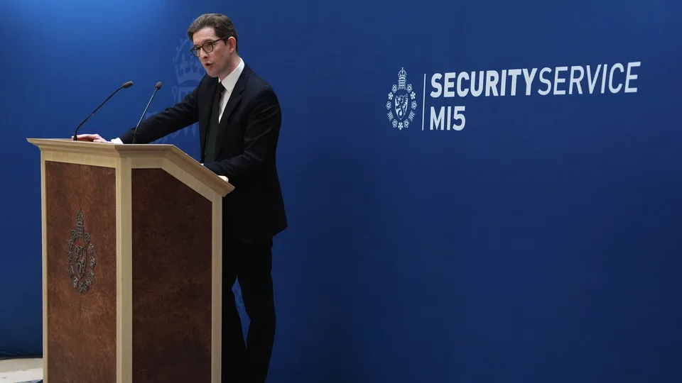 MI5 Director General Ken McCallum speaks at a lectern in front of a blue Security Service MI5 backdrop