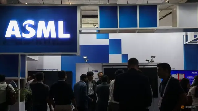 People gathered outside a blue-lit ASML booth at a trade show