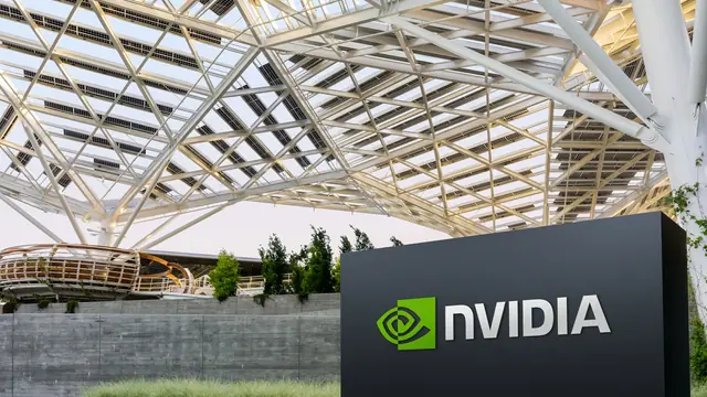 NVIDIA sign in front of its headquarters, which has a glass-and-steel lattice roof and trees